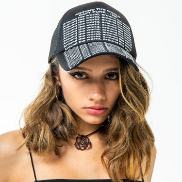 Woman wearing a black cap with text and a black top on a white background