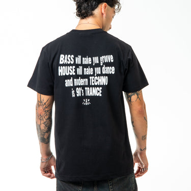 Person wearing a black t-shirt with text on the back, standing against a white background