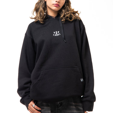 Person wearing a black hoodie with a logo on a white background