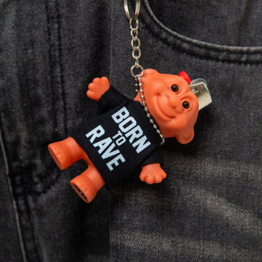 Keychain with 'Born to Rave' text attached to a person's pocket.