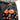 Two orange troll keychains with black shirts on a person's belt.