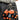 Two orange troll keychains with black shirts on a person's belt.