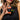 Person holding a small orange and black toy figure with text