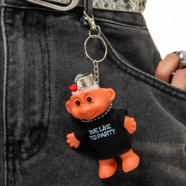 Person wearing a belt with a keychain shaped like a small orange creature in a black shirt.