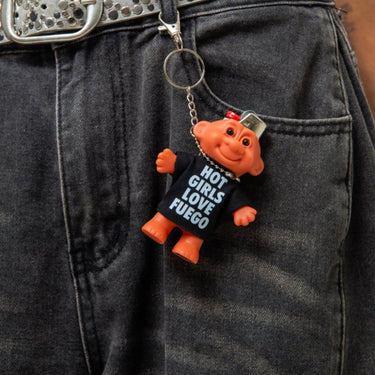 Person wearing dark jeans with a keychain featuring a small troll figure and text.