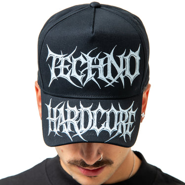 Person wearing a black cap with 'Techno Hardcore' text on a white background