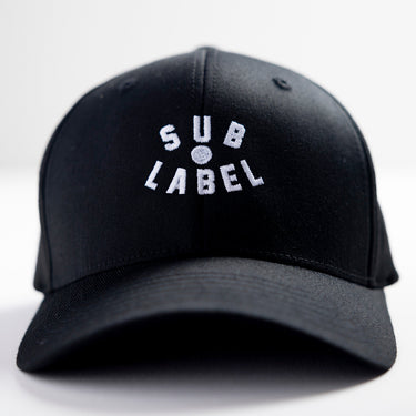 A black flex fitted cap with the text 'SUB LABEL' embroidered in white on the front.
