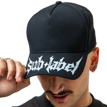 Person wearing a black cap with white text on a plain background