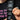 Person holding a black strap with 'SUB LABEL' branding, wearing a black shirt with pink text.