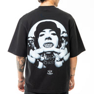 Person wearing a black t-shirt with a graphic design on the back, standing against a white background