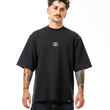 Man wearing a black t-shirt with a logo on a white background