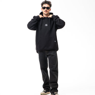 Person wearing a black hoodie and pants on a white background