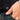 Hand holding a black jacket with 'SUB LABEL' patch