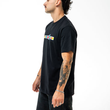 Person wearing a black t-shirt with colorful text design on a white background