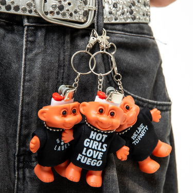 Two orange troll keychains with black shirts on a person's belt.