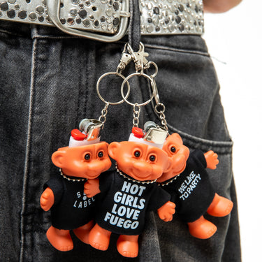 Two orange troll keychains with black shirts on a person's belt.