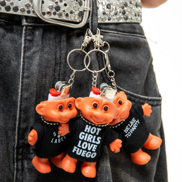Two orange troll keychains with black shirts on a person's belt.