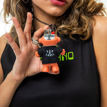 Person holding a small orange and black toy figure with text