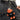 Person wearing a belt with a keychain shaped like a small orange creature in a black shirt.