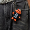 Person wearing dark jeans with a keychain featuring a small troll figure and text.