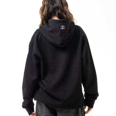 Person wearing a black hoodie with a logo on the back against a white background